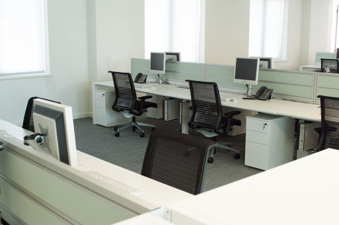 Office bench desks with monitor arms and screens