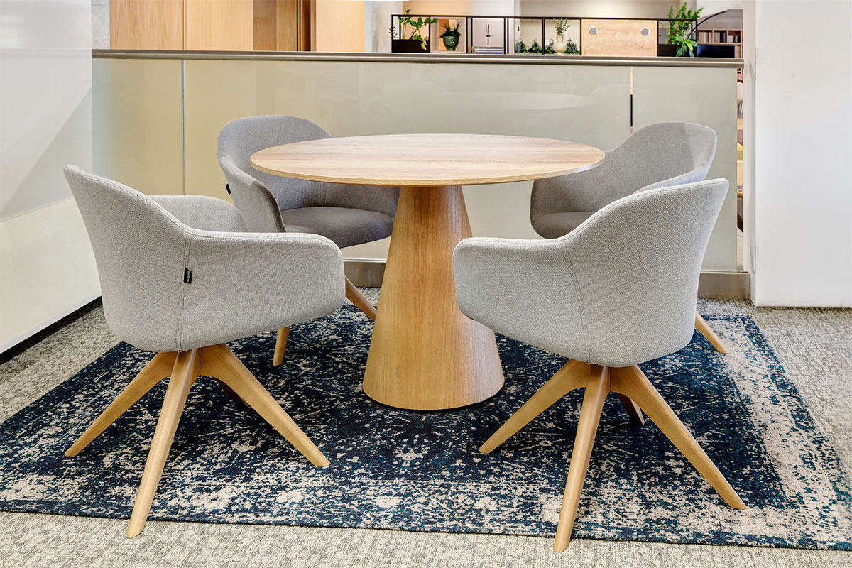 Upholstered meeting chair with wood base and meeting table